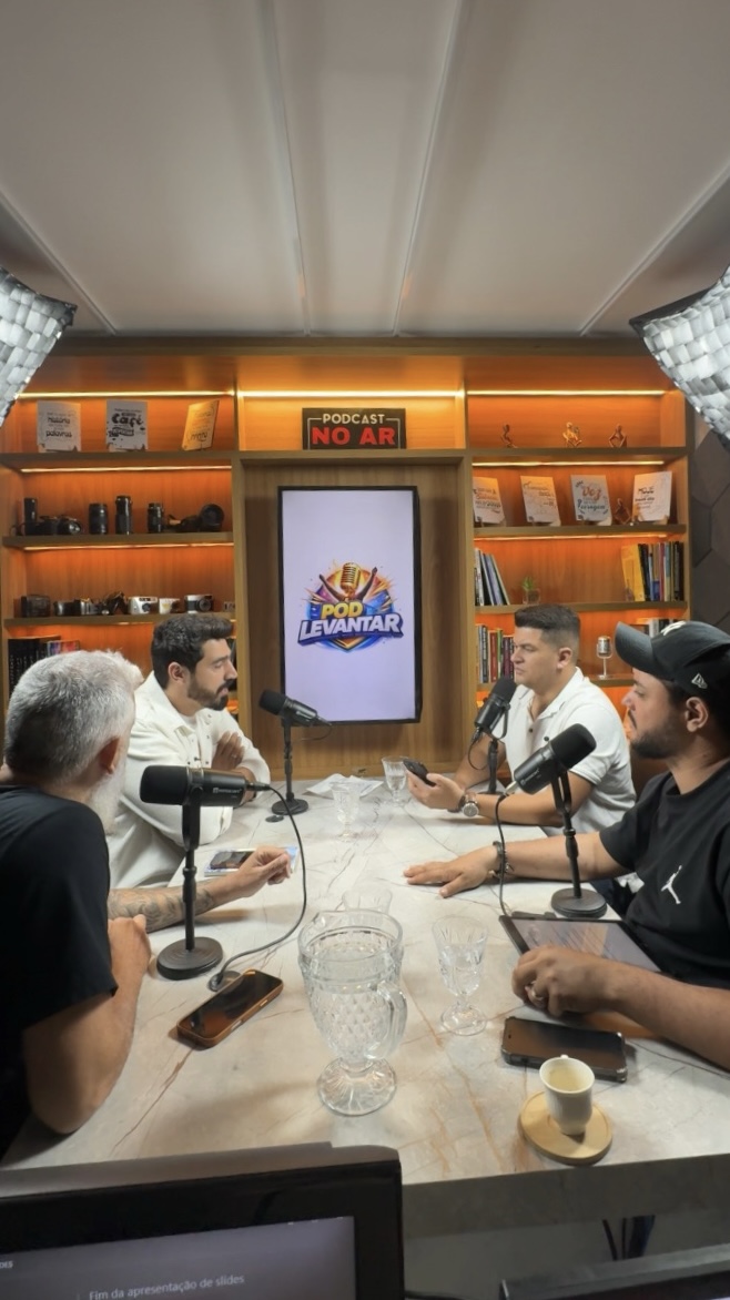Quatro participantes gravando um podcast à mesa no Studio V